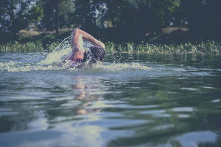The young man swimming in the river.の写真素材