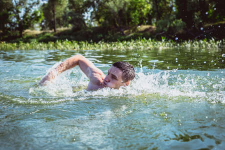 The young man swimming in the river.の写真素材