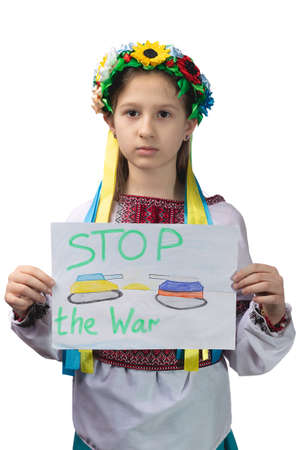 A little sad Ukrainian girl holds a drawing in her hands with the inscription "Stop the war". Studio photo on a white background.の写真素材