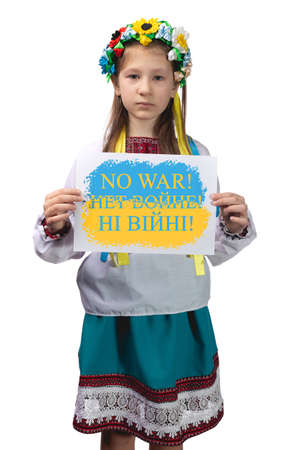 A little Ukrainian girl holds a piece of paper in her hands with the inscription "No to war!" in English, Russian and Ukrainian. Studio photo on a white background.の写真素材