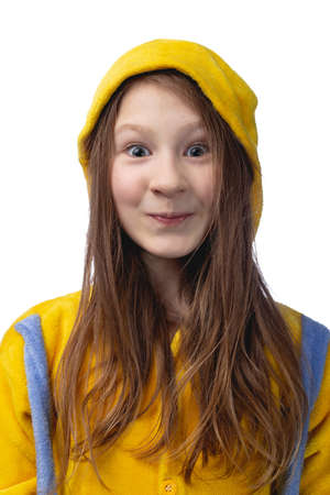 Little cute cheerful girl 10 years old posing in yellow pajamas. Studio photo on a white background.の写真素材