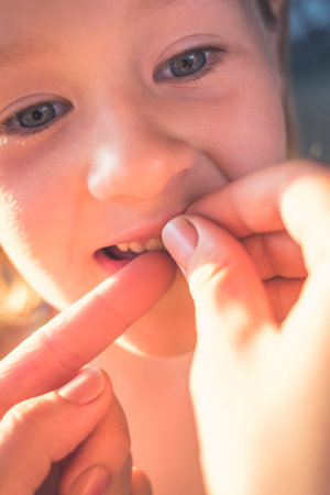 The process of removing a baby tooth using a thread.の写真素材