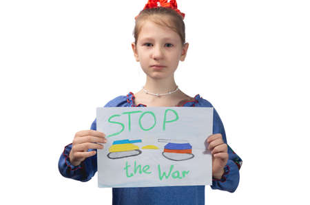 A little Ukrainian girl with tears in her eyes holds a drawing with the inscription "Stop the war" in her hands. Studio photo on a white background.の写真素材
