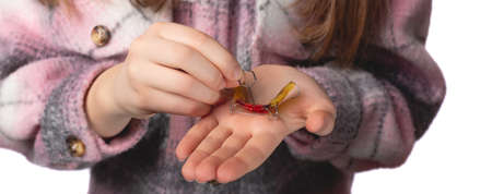 The child holds in his hands an orthodontic appliance and a key to adjust it. The concept of teeth alignment in childhood. Studio photo on a white background.の写真素材