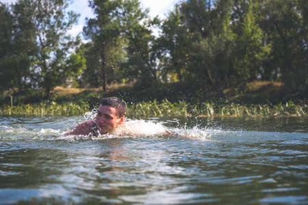 The young man swimming in the river.の写真素材