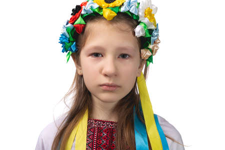Portrait of a little Ukrainian girl with tearful eyes. Child in national dress. Studio photo on a white background.の写真素材