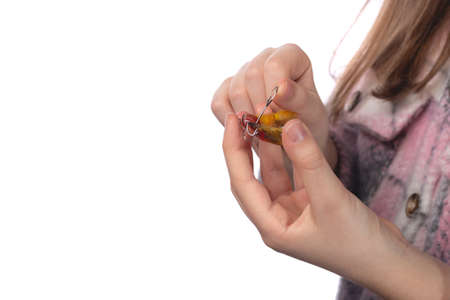 The child holds in his hands an orthodontic appliance and a key to adjust it. The concept of teeth alignment in childhood. Studio photo on a white background.の写真素材