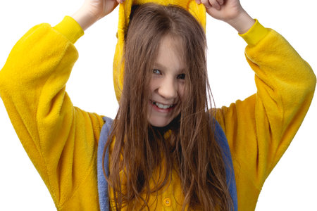 Little cute cheerful girl 10 years old posing in yellow pajamas. Studio photo on a white background.の写真素材