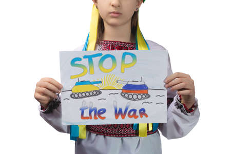 A little sad Ukrainian girl holds a drawing in her hands with the inscription "Stop the war". Studio photo on a white background.の写真素材