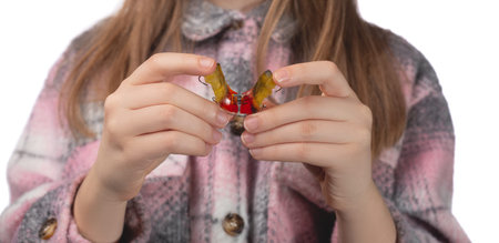 Cute little girl posing in the studio holding an orthodontic appliance in her hand. The concept of...