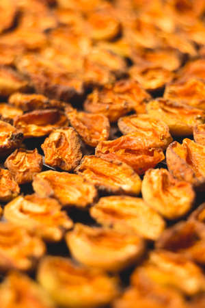 The process of home cooking dried fruits in an electric dryer. The stage of dehydration of fruits for storage and consumption in the winter. Lots of dehydrated apricots.の写真素材
