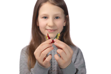 Cute little girl posing in the studio holding an orthodontic appliance in her hand. The concept of oral hygiene in childhood. Photo on a white background.の写真素材