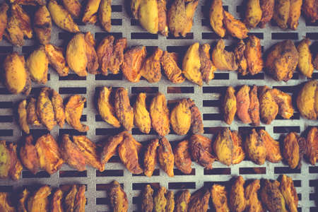The process of home cooking dried fruits in an electric dryer. The stage of dehydration of fruits for storage and consumption in the winter. Lots of dehydrated apricots.の写真素材