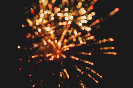 Fireworks in night sky with evergreen trees silhouetted in foreground.の写真素材