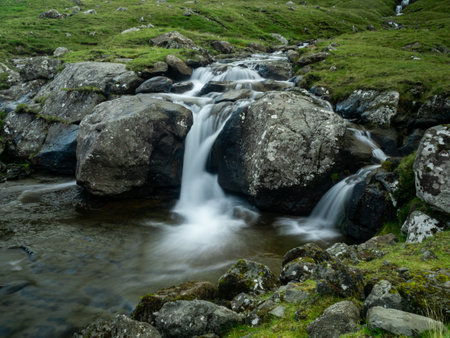 Faroe Islands, one of many waterfalls on road to abandoned town Muli. The waterfall is frozen, long exposure.の写真素材