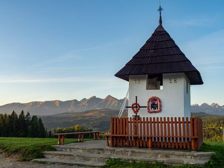 Small chapel on green field with Tatra Mountains in the background, Lapszanka, Polandの写真素材