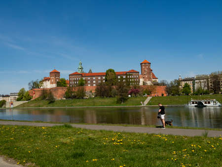 Cracow/Poland - 23/04/2020. The former Royal residence of Polish monarchy, Wawel Castle, Krakow, Poland. Spring time, view from the Vistula river boulevard. People relaxing during the covid-19 coronavirus pandemic.のeditorial素材