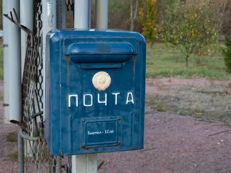Old mailbox in memorial complex in Chernobyl Exclusion Zone. Text on the box: post and taking out at 12:00. Chernobyl, Ukraineの写真素材