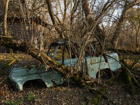An abandoned village  and car scrap within the Chernobyl exclusion zone. Ukraineの写真素材