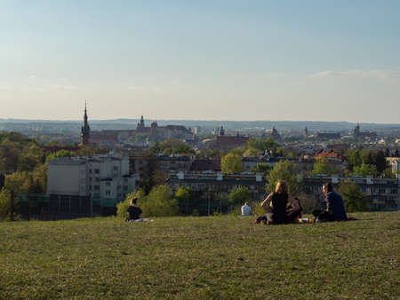 Cracow/Poland- 27/04/2020. View over old town of Cracow from Krakus mound. In the front people relaxing on the grassland.のeditorial素材