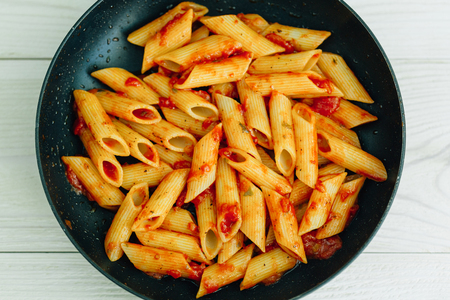 Penne pasta with tomato sauce in pan. Traditional italian meal. の写真素材