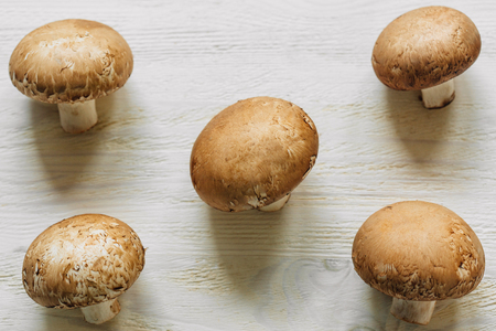 Brown champignon mushrooms lying on a wooden tableの写真素材