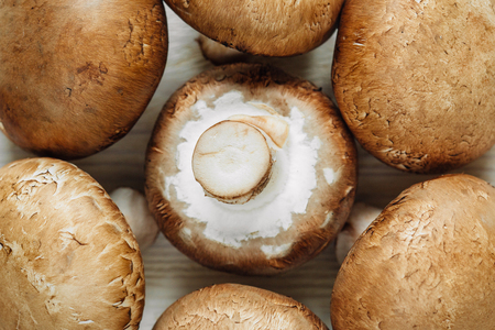 Brown champignon mushrooms lying on a wooden tableの写真素材