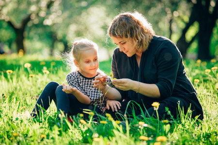 Mother and daughter having fun in the park. Happiness and harmony in family life.  Beauty nature...
