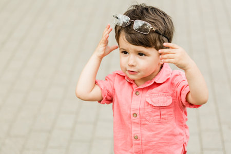 Cute little boy having fun in summer park. Happy child outdoors