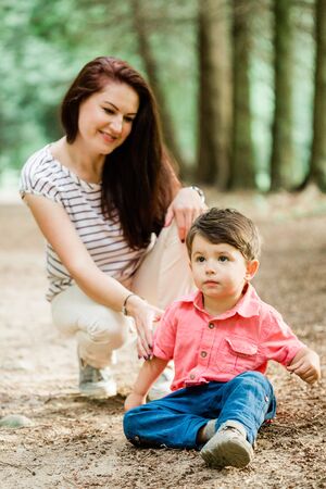 Mother having fun with cute son in summer park. Happy woman with cheerful little boy outdoorsの写真素材