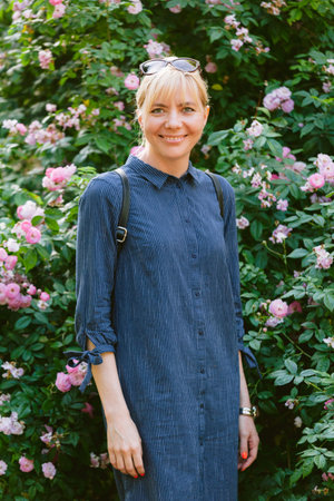 Pretty cheerful blonde girl posing outdoors. Cute smiling woman in parkの写真素材