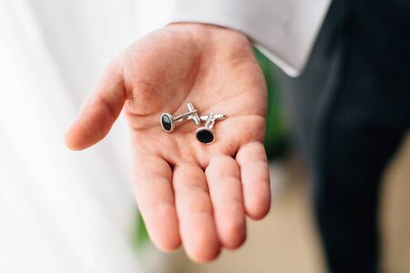 Close up Cufflinks on groom's hand. Wedding day. Man getting readyの写真素材