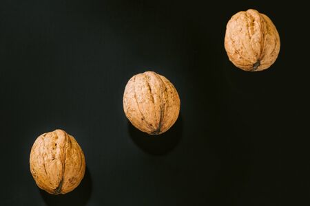 three Walnuts with shells on dark background. Background of fresh whole walnuts.の写真素材