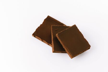 Macro photo of Chocolate bar. Broken pieces over white backgroundの写真素材
