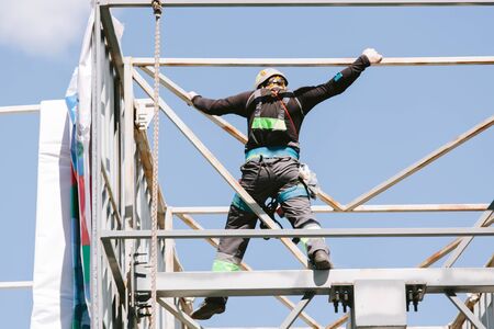 Industrial climber in helmet and overall working on height. Risky job. Professional workerの写真素材