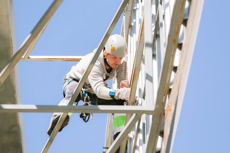 Industrial climber in helmet and overall working on height. Risky job. Professional workerの写真素材