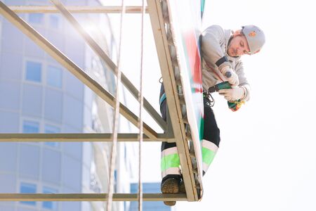 Industrial climber in helmet and overall working on height. Risky job. Professional workerの写真素材