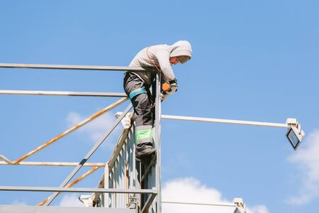 Industrial climber in helmet and overall working on height. Risky job. Professional workerの写真素材