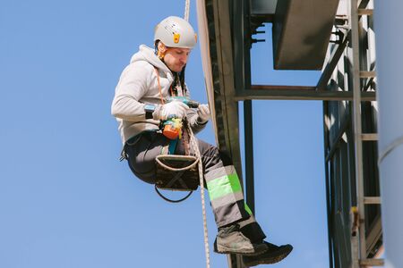 Industrial climber in helmet and overall working on height. Risky job. Professional workerの写真素材