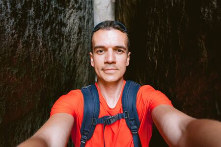 Young male hiker with backpack taking a selfie. Active healthy lifestyle adventure journey vacationsの写真素材