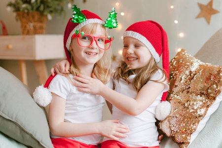 Two Happy cheerful Little girls in santa hat. Christmas time. Sisters having funの写真素材