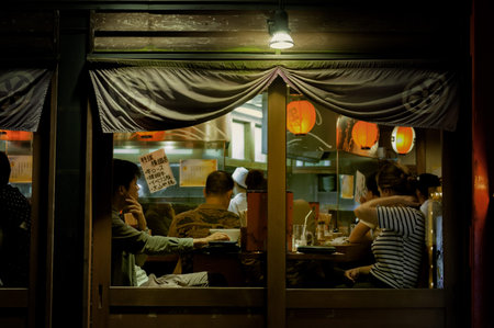 KYOTO, JAPAN - October 18, 2016 : DINING OUT AT A LOCAL JAPANESE RESTAURANT  A typical setting in a local Japanese restaurant. Some would sit next to counter on which the chef prepare meals, others prefer sitting elsewhere. A couple sat by the window haveのeditorial素材