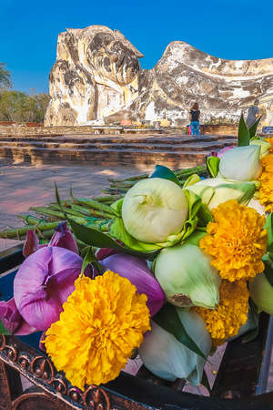 Reclining Buddha and Offering Flowers. Worshipers come to pray and offer flowers to the sleeping Buddha statue.の写真素材