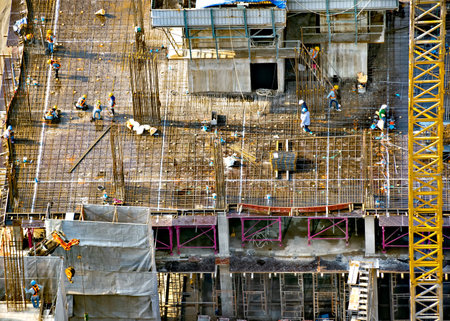 Aerial view of a building construction site in progress with tower crane, scaffolding, formwork,...
