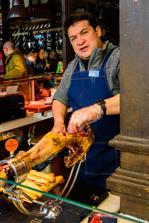 Mercado de San Miguel Market, Madrid â Jan 11, 2020: A fine gastronomic marketplace that caters to varieties of Spanish food. Here, slices of the finest Iberian ham are being prepared and served.のeditorial素材