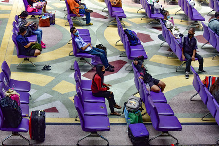 Bangkok, Thailand - March 20, 2021: Commuters at waiting hall at Bangkok Train Station - Hau Lumphong. Everyone wears a facemask and keeps their social distance.のeditorial素材