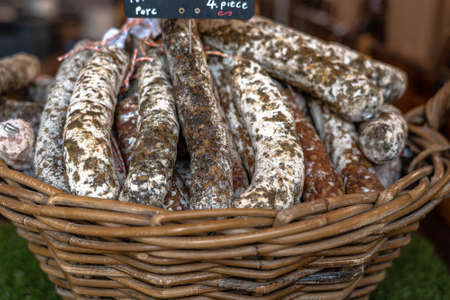 Stacks of dry-cured sausages - saucisson, typically made of pork, or a mixture of pork and other meats. Some variation contains spices and herbs, mushrooms, dried fruits, and nuts.の写真素材