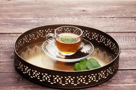 Tea. Herbal tea. Mint leaf. Tea in a glass cup, mint leaves, dried tea, sliced lime. herbs on a slate plate in a restaurant or teahouseの写真素材