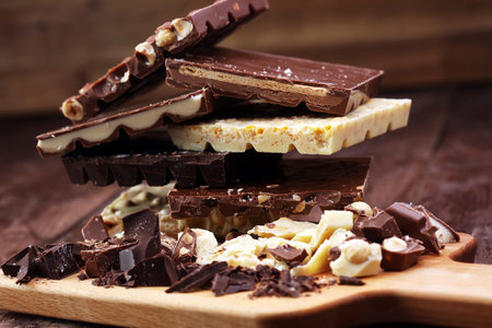 Chocolate bars on a wooden background with chocolate tower