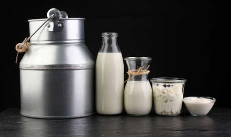 milk products - tasty healthy dairy products on a table on: sour cream in a white bowl, cottage cheese bowl, cream in a a bank and milk jar, glass bottle and in a glassの写真素材